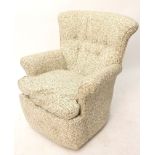 A buttoned-back easy chair upholstered white & green foliate material.