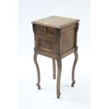 A continental oak bedside cabinet fitted frieze drawer above a cupboard enclosed by panel door &