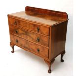 A mid-20th century walnut low chest fitted three long graduated drawers & on short cabriole legs &