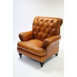 A MODERN TAN LEATHER BUTTONED-BACK ARMCHAIR, on turned feet.