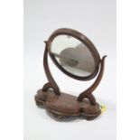 A Victorian mahogany oval swing dressing table mirror with scroll supports & on serpentine-front