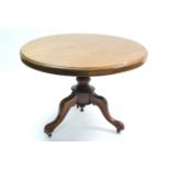 A Victorian mahogany loo table with circular tilt-top & on vase-turned centre column & three