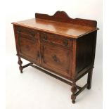 A 1930’s oak sideboard fitted two frieze drawers above cupboard enclosed by pair of panel doors & on