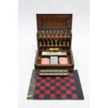 A LATE 19th/EARLY 20th CENTURY OAK GAMES COMPENDIUM fitted with a set of boxwood chessmen (size of