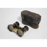 A pair of brass opera glasses with simulated tortoiseshell covered tubes, & with leather case.