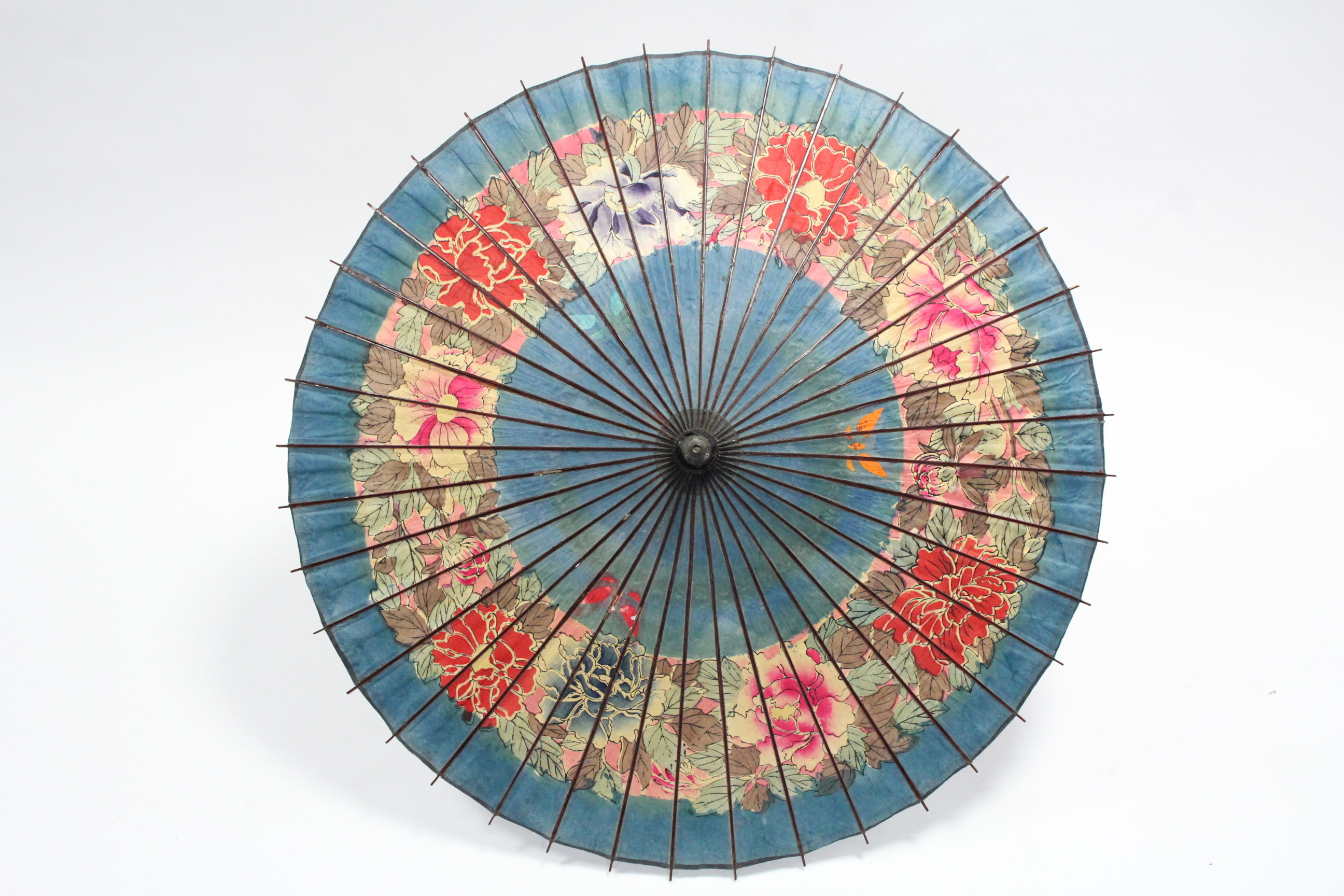 An early 20th century Chinese parasol with painted floral decoration; together with five various