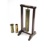 An early 20th century brass shell case, 25¾" high, converted to a dinner gong on mahogany stand,