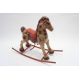 A mid-20th century Mobo(?) lithographed tinplate child’s rocking horse, 29” high x 26” long.