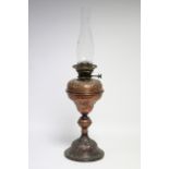 A Victorian embossed copper table oil lamp on circular base; 17½" high.