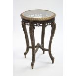 A giltwood circular occasional table with all over carved decoration, leaf scrolls to the four