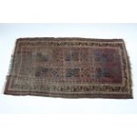 A 19th century Afghan rug of crimson ground, the centre with six rectangular geometric panels &