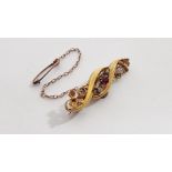 An Edwardian 15ct. gold scroll design brooch set ruby & two small diamonds; with safety chain;