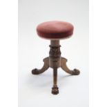 A William IV rosewood piano stool with circular padded rise-&-fall seat, on foliate-carved centre