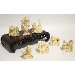 A GROUP OF SEVEN JAPANESE CARVED MARINE IVORY OKIMONO, comprising a standing male figure holding a