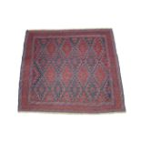 A tribal Kazak rug of madder ground with repeating dark blue lozenge design; 50" x 44".