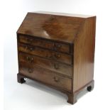 A late 18th century figured mahogany bureau with sloping fall front enclosing fitted interior with