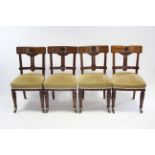 A set of four Victorian mahogany dining chairs with carved floral roundels to the open bow backs,