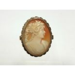 A 9ct. gold ring set oval carved shell cameo depicting a classical female bust.