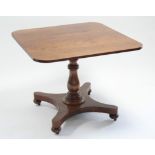 An early Victorian mahogany breakfast table with rectangular top on baluster turned centre
