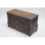A teak & brass-mounted ‘Zanzibar’ chest with hinged lid, carved front, iron side handles, & on