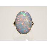 AN OPAL RING, the oval stone of strong colour measuring 19mm x 13mm, set to an un-marked yellow