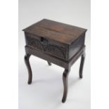 A late 17th century oak Bible box with hinged lid & foliate-carved front, 24" wide, on later stand