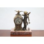 A late 19th century striking mantel clock in gilt metal case with cherub to the right, on rouge