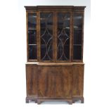 A GEORGE III STYLE MAHOGANY DWARF BREAK-FRONT BOOKCASE enclosed two pairs of glazed doors,