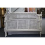 A French carved & painted double bedstead with cane-panel head & foot boards, on turned & fluted