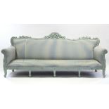 A French style sofa with carved & painted scroll frame, upholstered back, arms, & seat, & on short