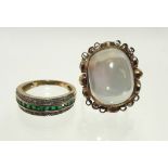 A 9ct. gold contemporary ring set large moonstone cabochon, & amethysts to the sides between applied