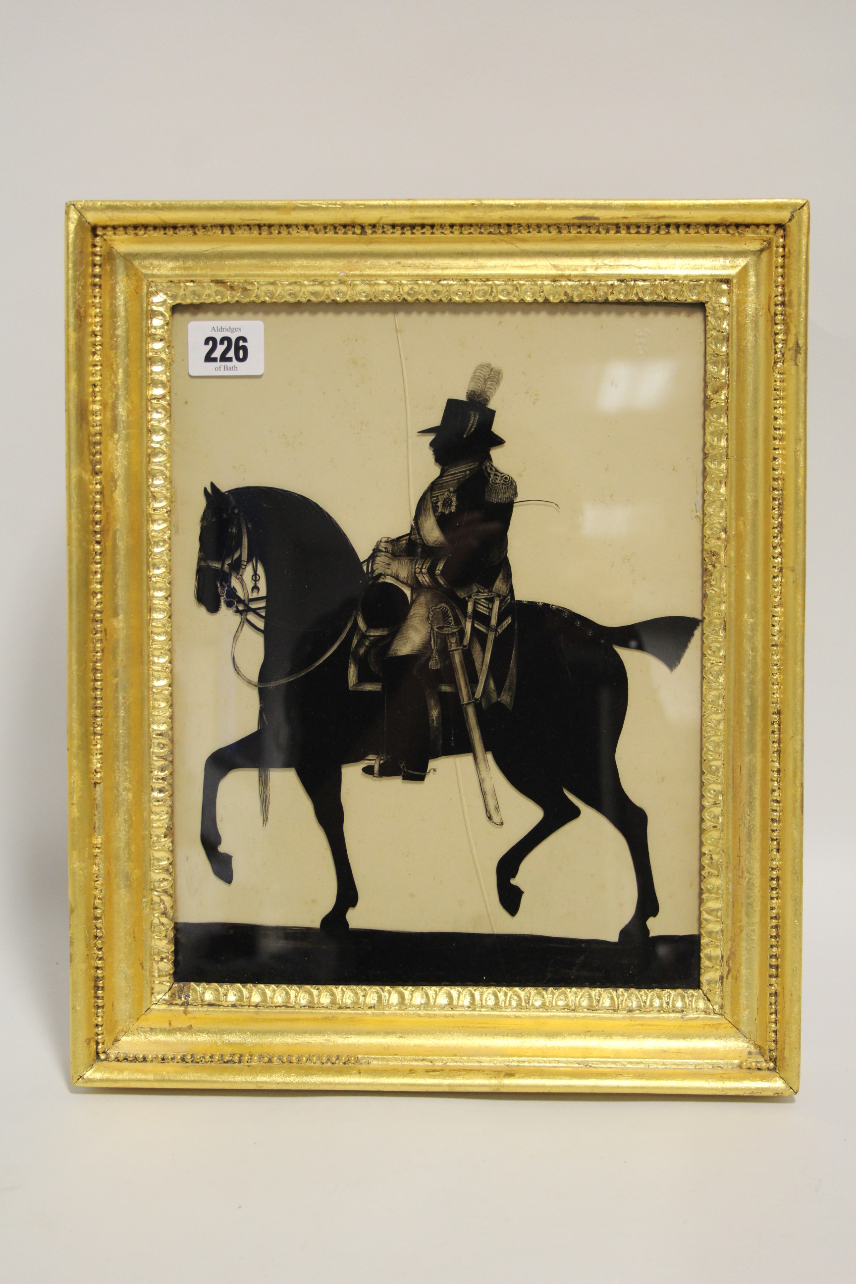 A late 18th century silhouette equestrian portrait of George III reverse-painted on glass bearing
