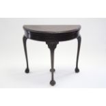 A Chippendale style mahogany card table, the demi-lune fold-over top with gadrooned edge, on four