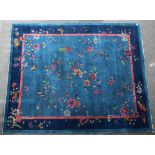 An early 20th century Chinese carpet of pale blue ground with scattered flowers, birds, &