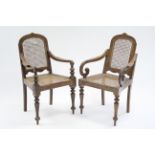 A near pair of Ceylonese teak elbow chairs, one bearing the trade label of H. Don Carolis & Sons,