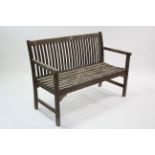 A teak slatted garden bench on square supports, 46¾” long.