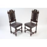 A pair of carved oak hall chairs with padded backs & sprung seats upholstered brown leather & on