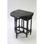 A 1930’s ebonised oak oval gate-leg occasional table on barley-twist legs & turned feet with plain