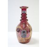 A Cranberry tinted & gilt overlaid ovoid decanter decorated with four male portrait panels (