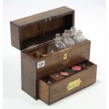 A 19th century mahogany apothecary’s box part fitted with numerous glass bottles, a set of scales,