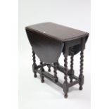 A 1930’s small oak gate leg table with oval top, & on barley-twist legs & turned feet with plain