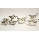 A set of four oblong salt cellars with gadroon & shell borders, each on pedestal foot; a pair of