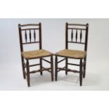 A pair of late 19th/early 20th century ash spindle-back cottage dining chairs with woven rush