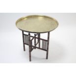 An eastern brass engraved tray-top occasional table on folding hardwood stand, 22¾” diam.