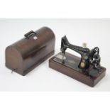 A Singer hand sewing machine with carrying case.