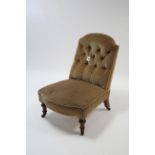 A late Victorian buttoned-back nursing chair upholstered fawn velour, & on short turned legs with