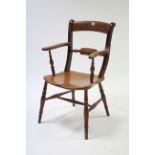 A late Victorian bow-back carver chair with hard seat, &on turned legs with spindle stretchers.