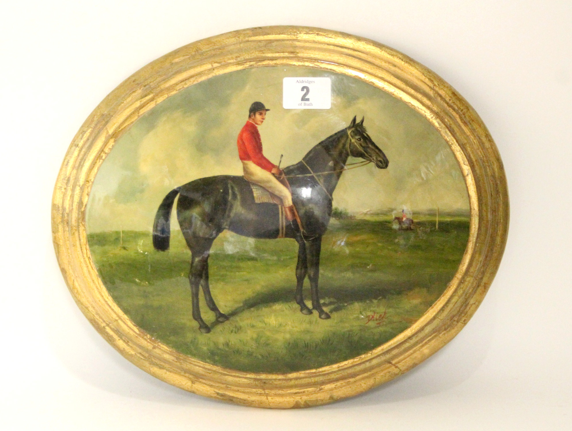 An oval convex oil painting depicting a racehorse & jockey, 8” x 10”, in gilt frame.