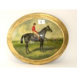 An oval convex oil painting depicting a racehorse & jockey, 8” x 10”, in gilt frame.