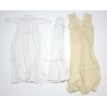 Two Edwardian white cotton children’s nightgowns; & a mid-20th century cream satin ladies’ nightie.